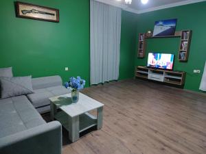 a living room with a couch and a tv at Guest House MARTA in Kobuleti