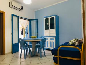 a dining room with blue walls and a table and chairs at OSTUNIRESIDENCE baia camerini in Villanova di Ostuni