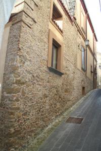 a building with a stone wall next to a street at B&B Del Borgo in San Marco Argentano