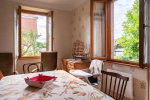La Maison de Vacances de Colmar et son jardin في كولمار: غرفة طعام مع طاولة مع وعاء عليها