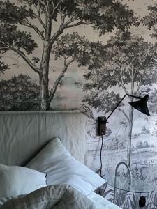 a bedroom with a bed and a wall with trees at Rallarhustruns in Hässleholm