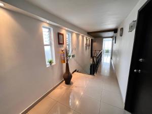a hallway with white walls and a vase on the floor at Hotel Volare in Armenia