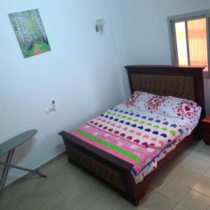 a small bed in a room with a table at Appartement Meublé 2 et 3 Chambres Avec Groupe Électrogène À Makèpè in Douala