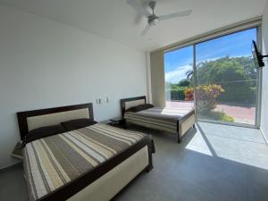 une chambre avec deux lits et une grande fenêtre dans l'établissement Peñalisa casa vacacional de lujo, à Ricaurte 21 autres photos