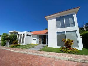 une maison blanche avec un toit rouge dans l'établissement Peñalisa casa vacacional de lujo, à Ricaurte