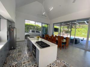 リカウルテにあるPeñalisa casa vacacional de lujoのキッチン(白いカウンター、テーブル、椅子付)