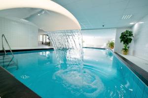 een zwembad met een fontein in een gebouw bij Strandhochhaus SG10 in Cuxhaven