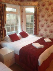 2 camas en una habitación con 2 ventanas en The Bridge House en Hounslow