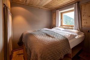 a bed in a room with a window at Neve e Sole in Selva di Val Gardena