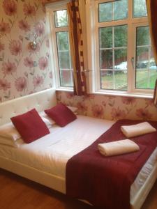 a bed in a room with two windows at The Bridge House in Hounslow