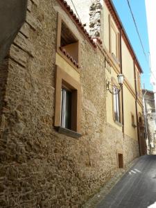 un edificio in pietra con finestra su strada di B&B Del Borgo a San Marco Argentano