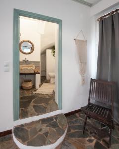 a bathroom with a mirror and a chair and a tub at Stonehouse_ioa in Ioannina