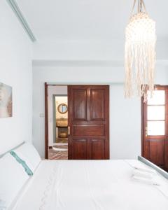 a bedroom with a white bed and a chandelier at Stonehouse_ioa in Ioannina