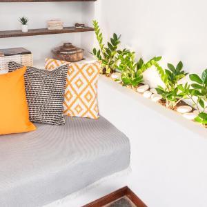 a bench with pillows and plants on a wall at Stonehouse_ioa in Ioannina