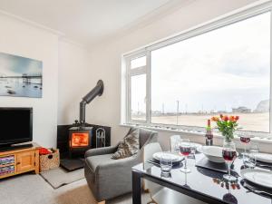 a living room with a table and a fireplace at Little Orme View in Llandudno
