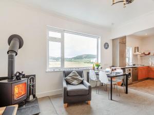 a kitchen and living room with a stove and a table at Little Orme View in Llandudno