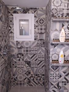 a bathroom with black and white tiles on the wall at Mentoras' Complex in Emporio
