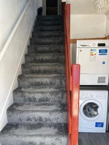 a staircase with a washer and dryer next to a washing machine at H &P accommodation in Plymouth