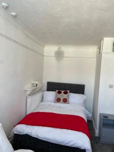 a bedroom with a bed with a red and white blanket at H &P accommodation in Plymouth