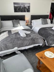 a bedroom with two beds and a coffee table at H &P accommodation in Plymouth