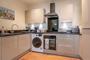 uma cozinha com um fogão e uma máquina de lavar e secar roupa em Hunter House Holiday Apartment - York em York