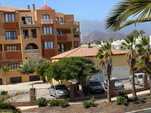 un edificio con auto parcheggiate in un parcheggio di Villa Moleiro - Golf del Sur a San Miguel de Abona