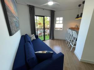 un soggiorno con un divano blu e una cucina di Villa Moleiro - Golf del Sur a San Miguel de Abona