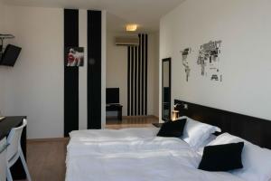 a bedroom with a large white bed with black accents at Berghotel in Bergamo