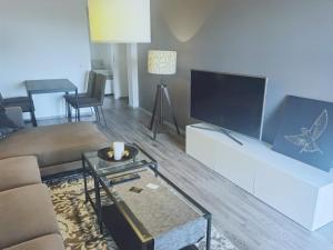 a living room with a couch and a flat screen tv at Gästehaus, Ferienwohnung, Monteurwohnung, Stedinger Landhotel in Berne