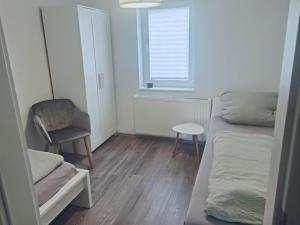 ein Schlafzimmer mit einem Bett und einem Stuhl und einem Fenster in der Unterkunft Gästehaus, Ferienwohnung, Monteurwohnung, Stedinger Landhotel in Berne