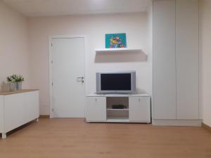 een woonkamer met een tv aan een witte muur bij LOFT FRIOL in Friol