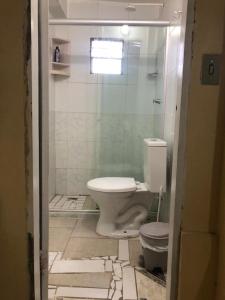 uma casa de banho com um WC e uma cabina de duche em vidro. em Casa na Praia de Barra do Gil em Vera Cruz de Itaparica
