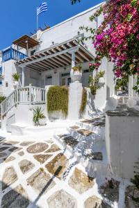 una casa blanca con flores delante en Floral Villa with marvelous view to Mykonos town en Mykonos