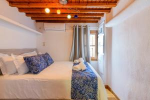 1 dormitorio con 1 cama grande con almohadas azules y blancas en Floral Villa with marvelous view to Mykonos town, en Mykonos ciudad
