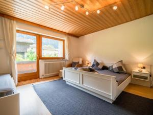 1 dormitorio con 1 cama grande y techo de madera en Ferienhaus Schlitters en Fügen