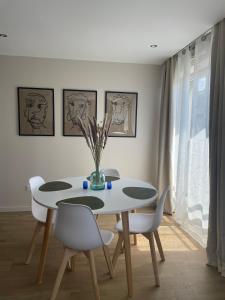 una sala da pranzo con tavolo e sedie bianchi di Charmant logement aux portes de Paris - STADE DE FRANCE - 12 min à pied a Saint-Denis