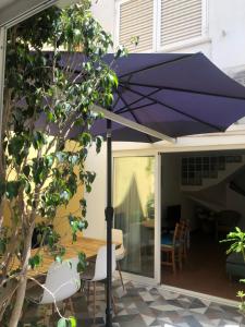 a purple umbrella on the patio of a house at Tavira Downtown Calm House in Tavira