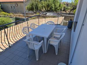 a white table and chairs on a balcony at Nina's house 2, a 300 metri dal mare in Santa Caterina Dello Ionio Marina