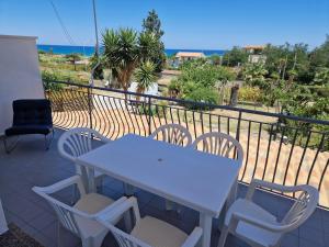 einen weißen Tisch und Stühle auf einem Balkon mit Meerblick in der Unterkunft Nina's house 2, a 300 metri dal mare in Santa Caterina Dello Ionio Marina
