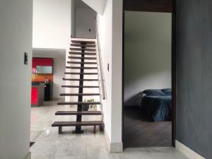 Una escalera que conduce a una habitación con dormitorio en Comfort Campestre, en Tabio