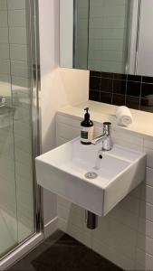 a bathroom with a white sink and a shower at Modern Luxurious with private parking on premises and fast internet in Melbourne