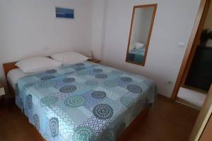 a bedroom with a bed with a blue blanket and a mirror at Apartments with parking space Makarska - 6850 in Makarska