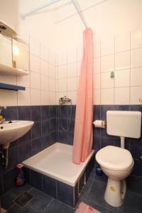a bathroom with a tub and a toilet and a sink at Apartments with parking space Makarska - 6729 in Makarska