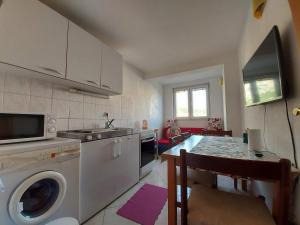 a kitchen with a washing machine and a table at Apartments with parking space Makarska - 6729 in Makarska +17 photos