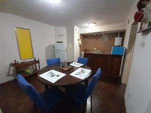 a dining room with a table and blue chairs at Leo IV in San Fernando del Valle de Catamarca