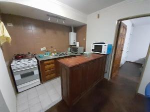 a kitchen with a sink and a stove and a microwave at Leo IV in San Fernando del Valle de Catamarca +4 photos