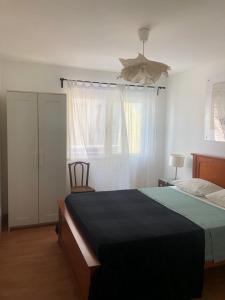 a bedroom with a bed and a window with a fan at Tavira Downtown Calm House in Tavira