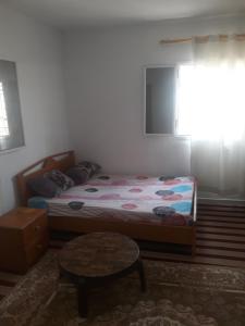 a bedroom with a bed and a table and a window at transit in Nouakchott