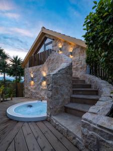 uma banheira de hidromassagem num deque com uma casa em Azor Eco Lodge em São Vicente Ferreira