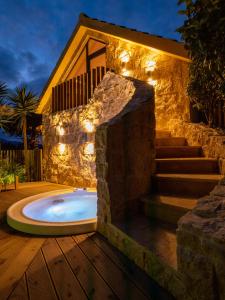 a jacuzzi tub in a yard with a house at Azor Eco Lodge in São Vicente Ferreira